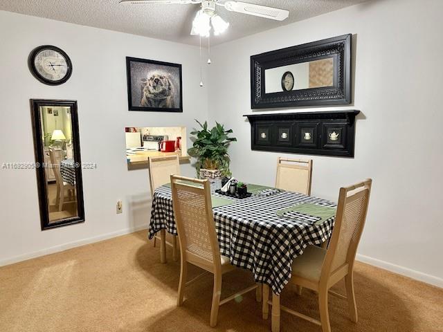 dining room with carpet flooring, ceiling fan, and a textured ceiling