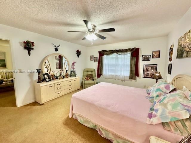 bedroom with a textured ceiling, ceiling fan, and light carpet