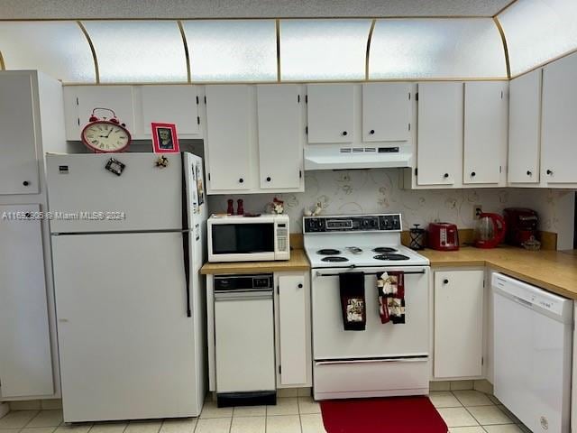 kitchen featuring white cabinets, light tile patterned floors, and white appliances