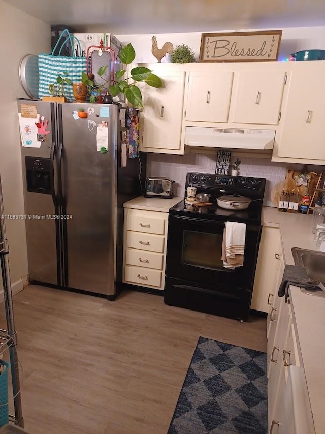 kitchen featuring light wood-type flooring, stainless steel refrigerator with ice dispenser, black range with electric cooktop, and backsplash