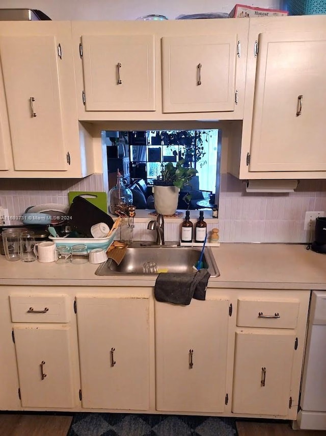 kitchen featuring dishwasher, white cabinetry, sink, and tasteful backsplash