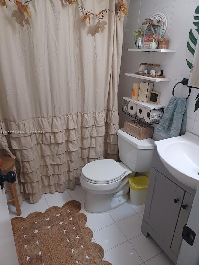 bathroom with tile patterned floors, vanity, toilet, and tile walls