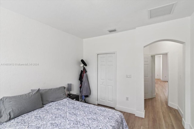 bedroom with a closet and light hardwood / wood-style flooring