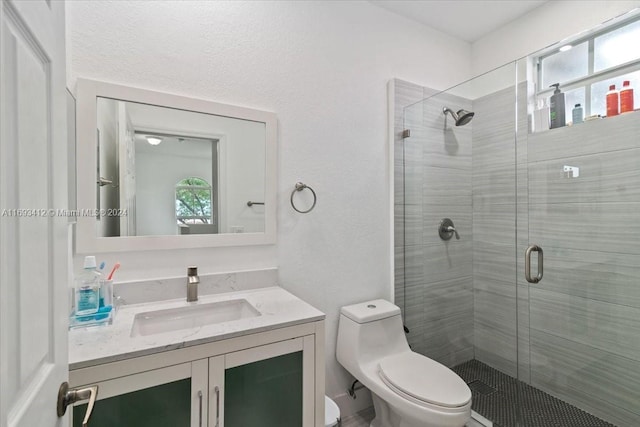 bathroom with walk in shower, a wealth of natural light, vanity, and toilet