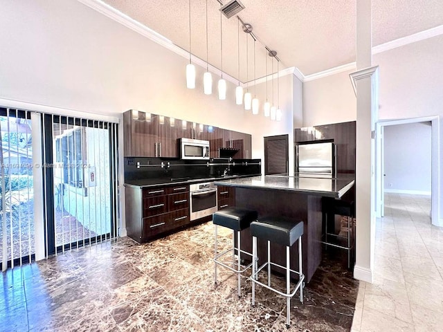 kitchen with a center island, a kitchen breakfast bar, a textured ceiling, dark brown cabinets, and stainless steel appliances