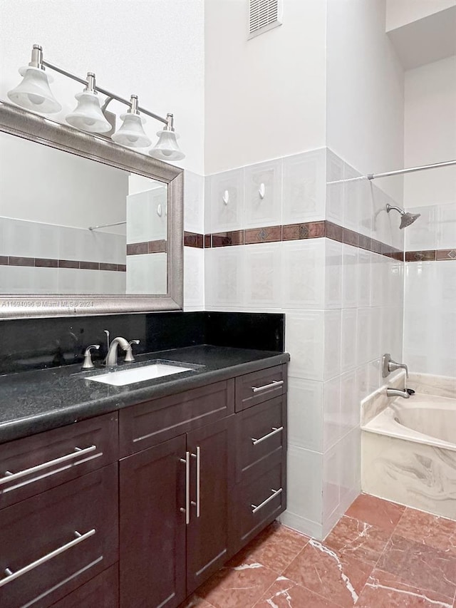 bathroom featuring vanity and tiled shower / bath