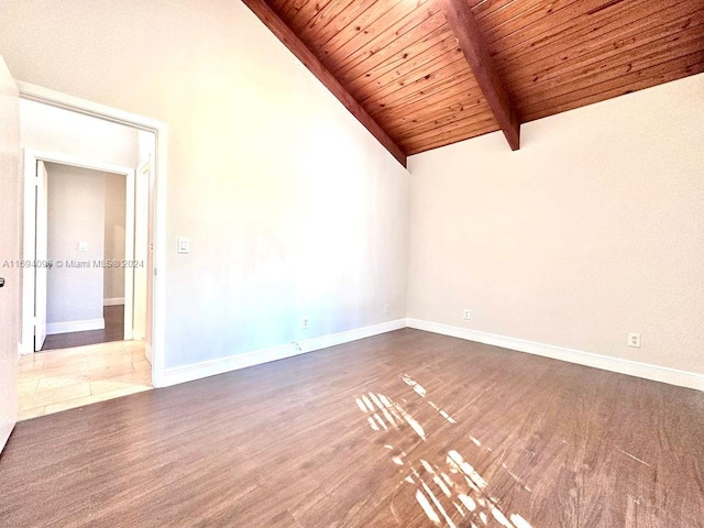 empty room with vaulted ceiling with beams, dark hardwood / wood-style flooring, and wooden ceiling