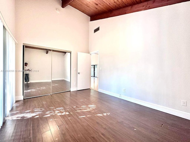 unfurnished bedroom with dark hardwood / wood-style flooring, wood ceiling, beam ceiling, high vaulted ceiling, and a closet