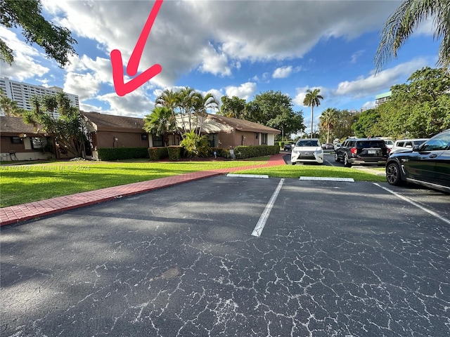 view of vehicle parking with a lawn