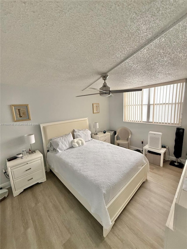 bedroom featuring a textured ceiling, light hardwood / wood-style flooring, and ceiling fan