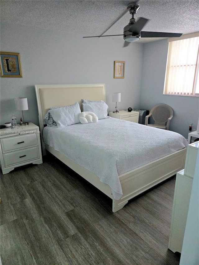 bedroom with ceiling fan, dark hardwood / wood-style floors, and a textured ceiling