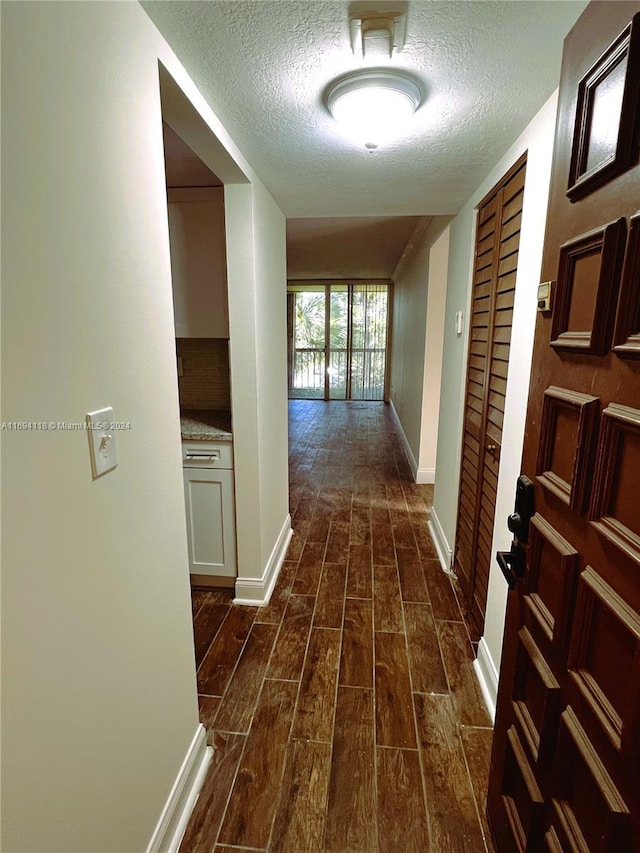 hall featuring dark hardwood / wood-style flooring and a textured ceiling