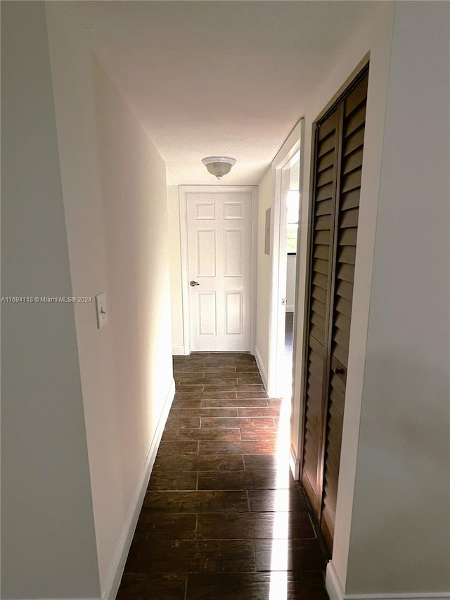 corridor with dark hardwood / wood-style flooring