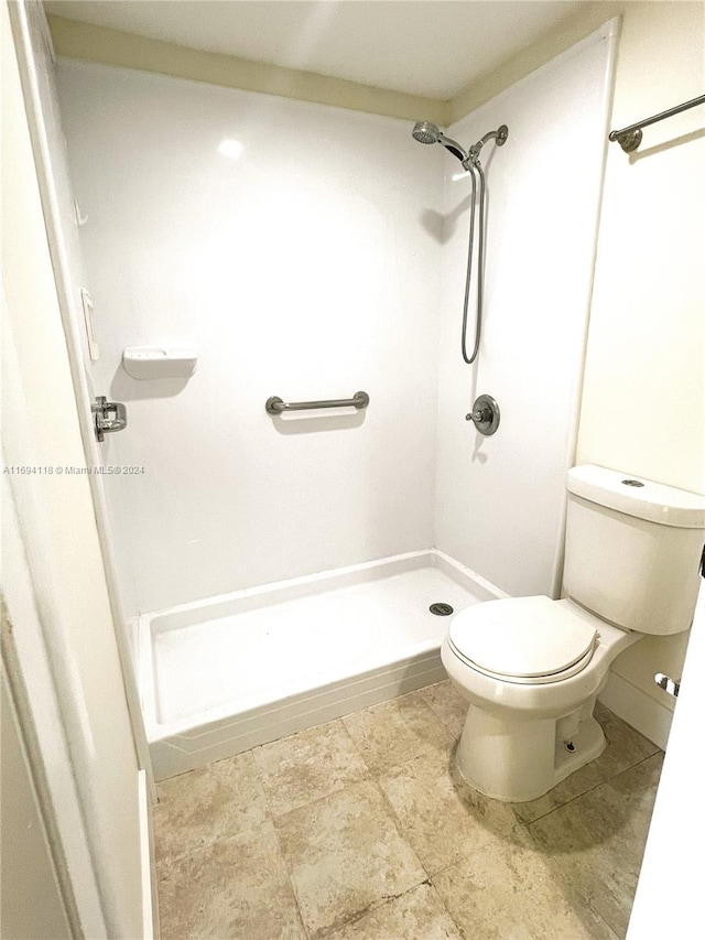 bathroom featuring a shower and toilet