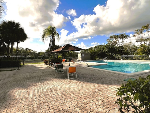 view of pool featuring a gazebo, a patio area, and a shed