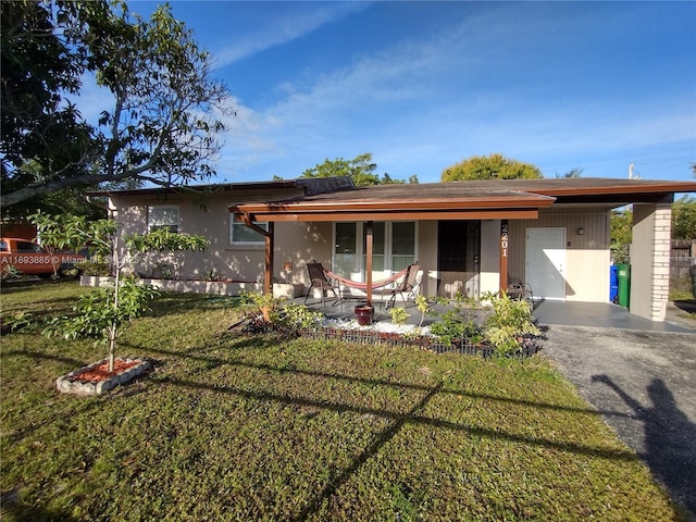 ranch-style house featuring a porch, a carport, and a front lawn