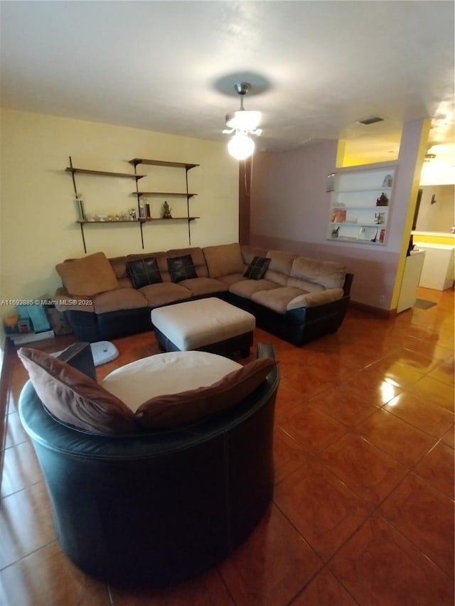 living room featuring built in features and ceiling fan