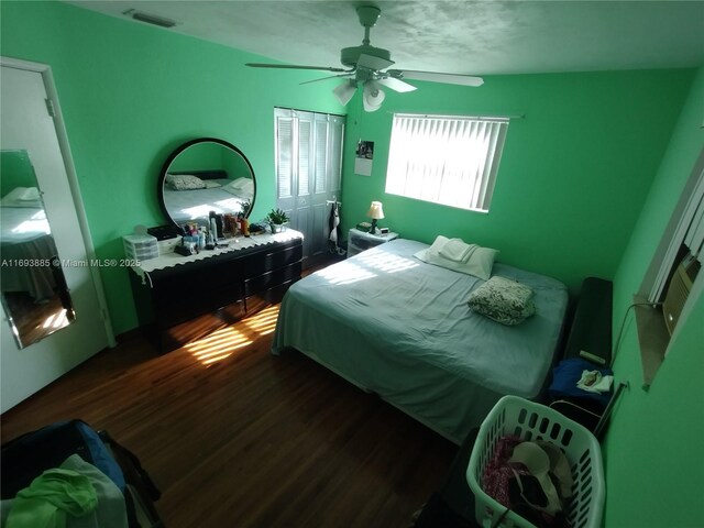 bedroom featuring ceiling fan, a closet, and dark wood-type flooring