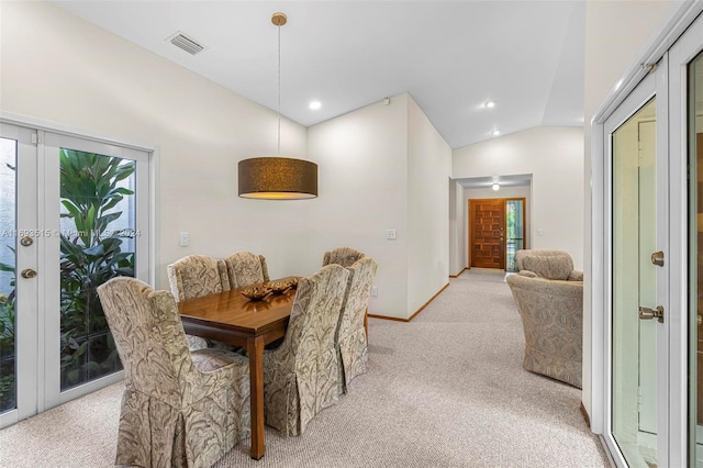 dining room with light carpet and vaulted ceiling