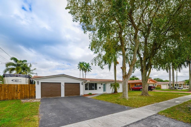 single story home with a front lawn, fence, driveway, and an attached garage