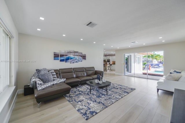living area featuring recessed lighting, baseboards, light wood finished floors, and visible vents