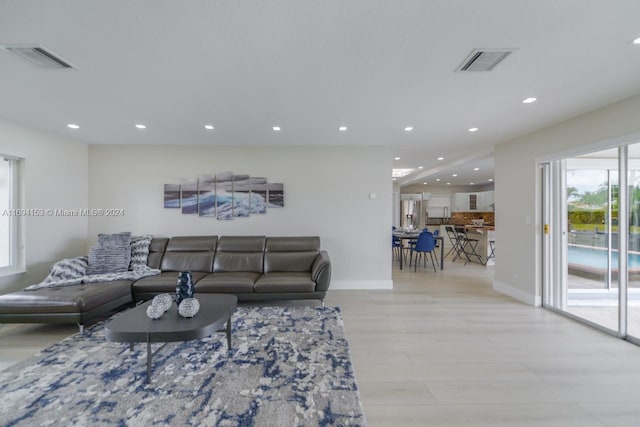 living area with wood finished floors, recessed lighting, baseboards, and visible vents