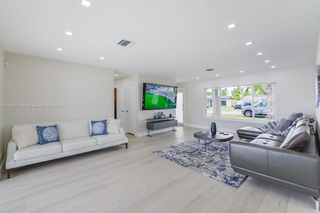 living area featuring baseboards, visible vents, wood finished floors, and recessed lighting