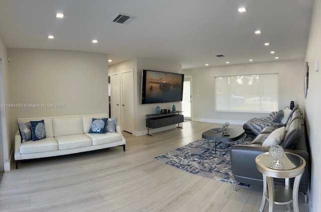 living room with baseboards, visible vents, light wood-style floors, and recessed lighting