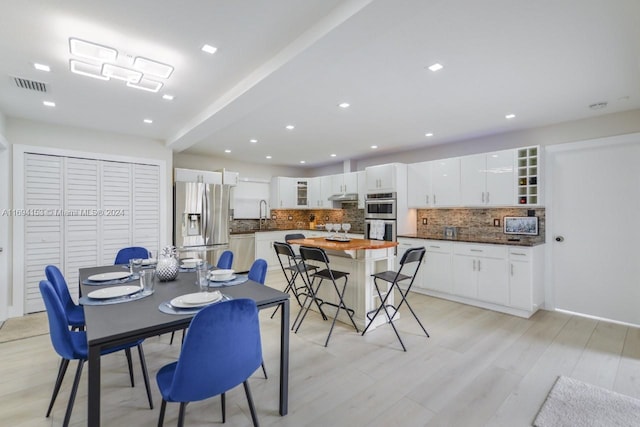 dining area with light wood-type flooring, recessed lighting, and visible vents