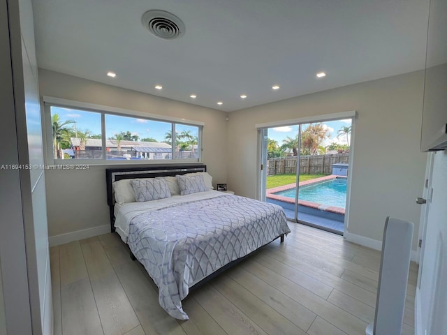 bedroom with access to exterior, visible vents, multiple windows, and light wood-type flooring