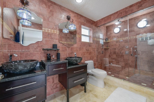 bathroom featuring tile walls, vanity, toilet, and tiled shower