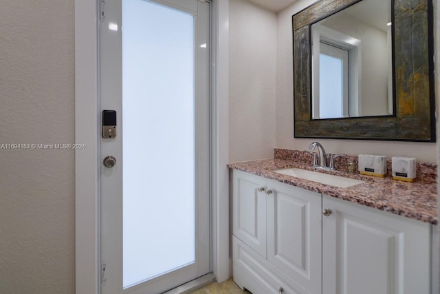 bathroom featuring a textured wall and vanity
