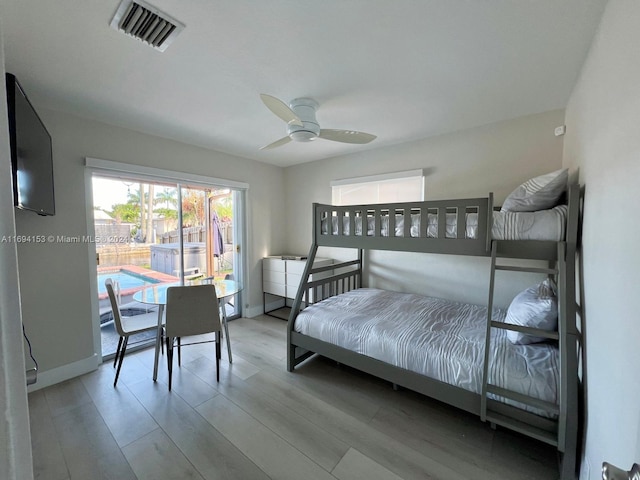 bedroom with baseboards, visible vents, a ceiling fan, and wood finished floors