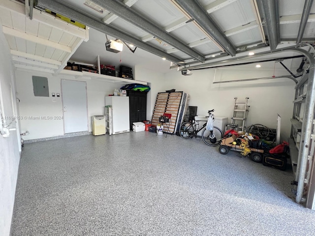 garage with freestanding refrigerator, electric panel, and a garage door opener