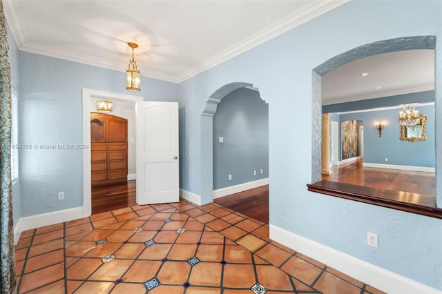 unfurnished room featuring wood-type flooring, an inviting chandelier, and crown molding