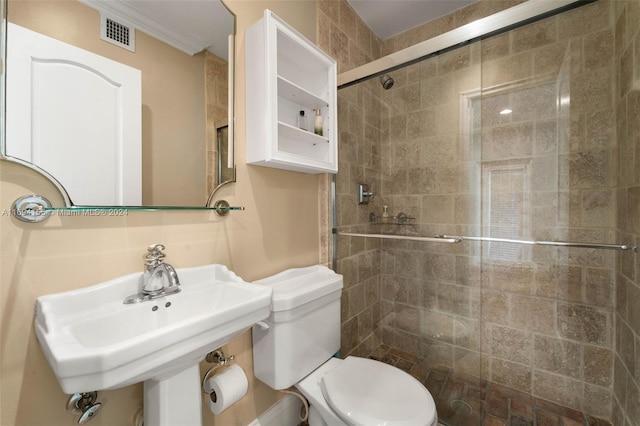 bathroom with toilet, a shower with shower door, and sink