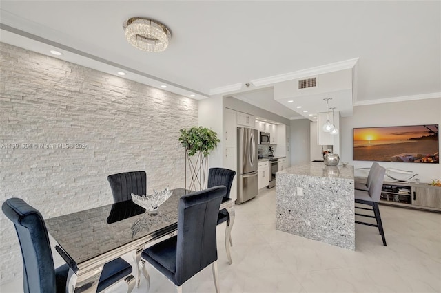 dining space with ornamental molding and a chandelier