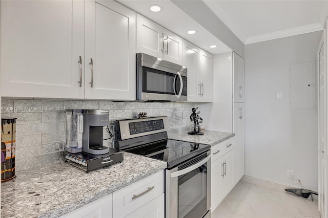 kitchen with white cabinets, light stone counters, backsplash, and appliances with stainless steel finishes