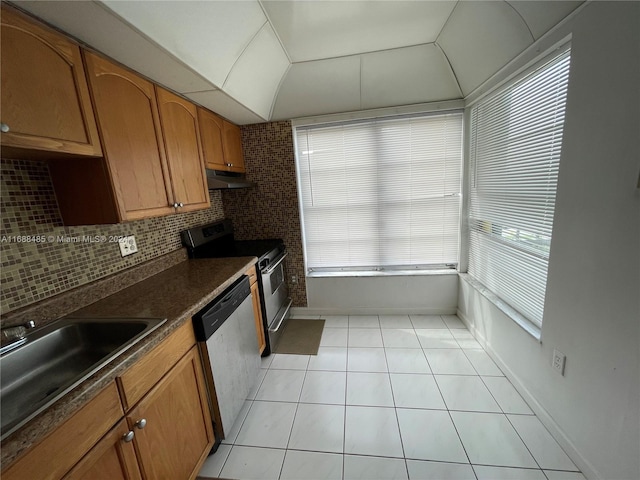 kitchen featuring lofted ceiling, sink, decorative backsplash, light tile patterned flooring, and stainless steel appliances