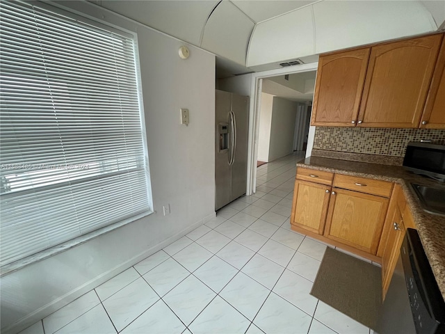 kitchen featuring a healthy amount of sunlight, light tile patterned floors, backsplash, and appliances with stainless steel finishes