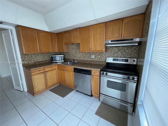 kitchen with light tile patterned floors, backsplash, stainless steel appliances, and sink