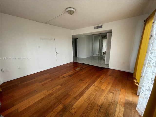 unfurnished bedroom with wood-type flooring and a textured ceiling