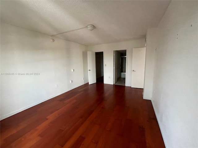 empty room featuring wood-type flooring and a textured ceiling