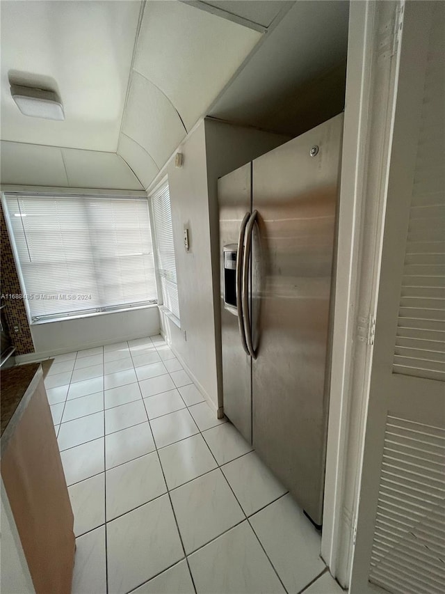 kitchen with light tile patterned floors and stainless steel refrigerator with ice dispenser