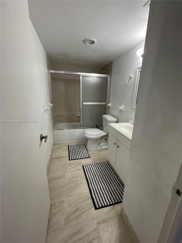 full bathroom with vanity, toilet, and shower / bath combination with glass door