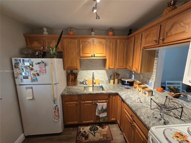 kitchen with sink, light stone counters, dark hardwood / wood-style flooring, backsplash, and white fridge