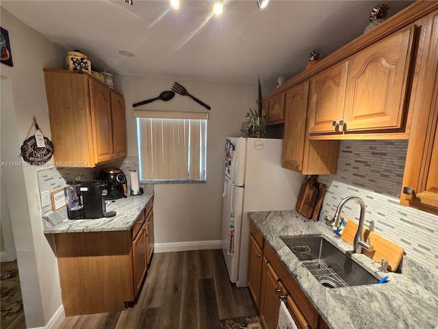 kitchen with dark hardwood / wood-style flooring, tasteful backsplash, light stone counters, and sink