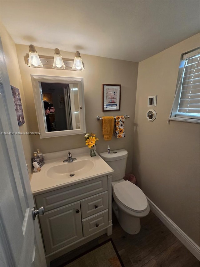 bathroom with hardwood / wood-style floors, vanity, and toilet