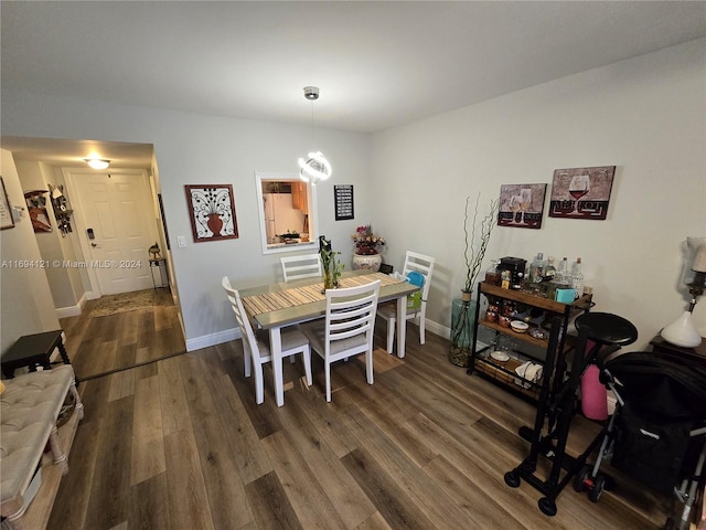 dining area featuring dark hardwood / wood-style floors and an inviting chandelier