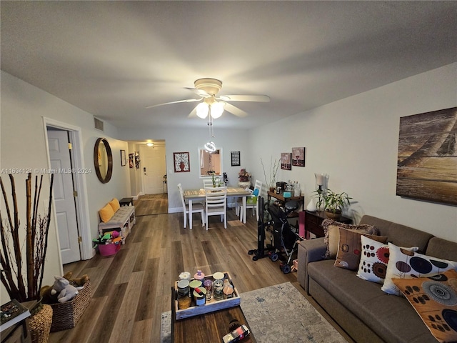 living room with ceiling fan and dark wood-type flooring